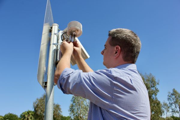 A person installing a heat sensor is installed in Dubbo for the Smart and Cool Places project.